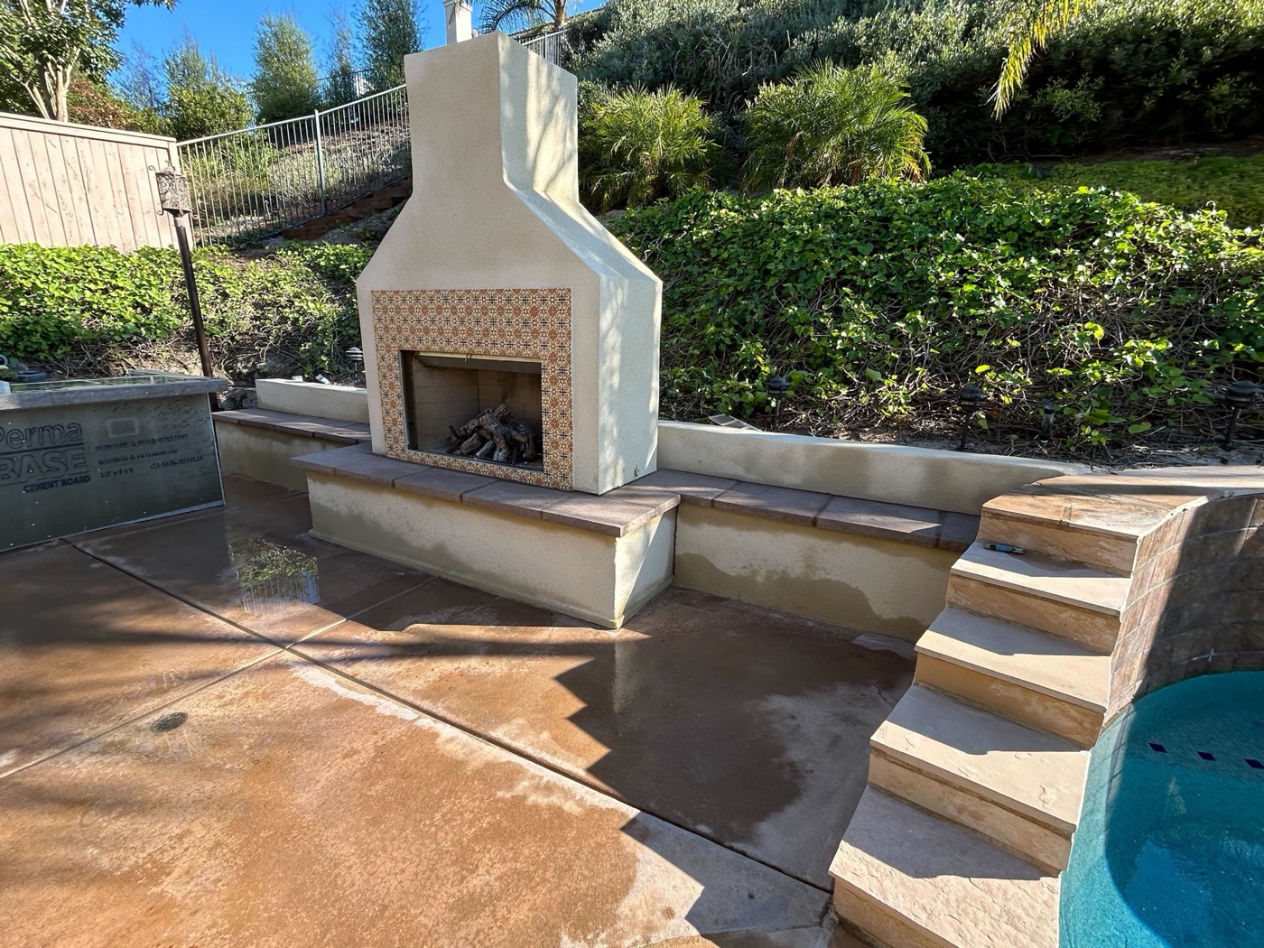 Outdoor fireplace beside the pool in Lafayette by Abshire Brothers Lawn & Landscape