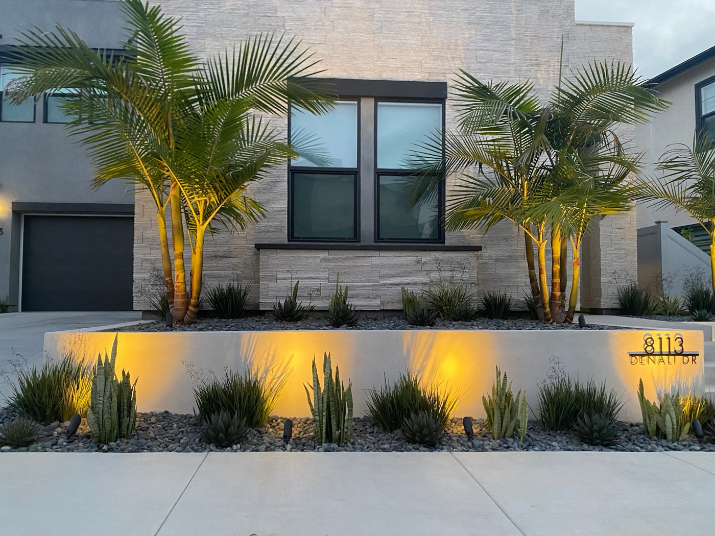 Modern home facade with landscape lighting in Youngsville by Abshire Brothers Lawn & Landscape