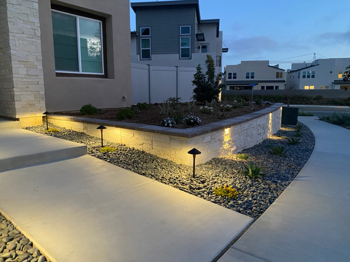 Front-yard planter wall with landscape lighting in Youngsville by Abshire Brothers Lawn & Landscape