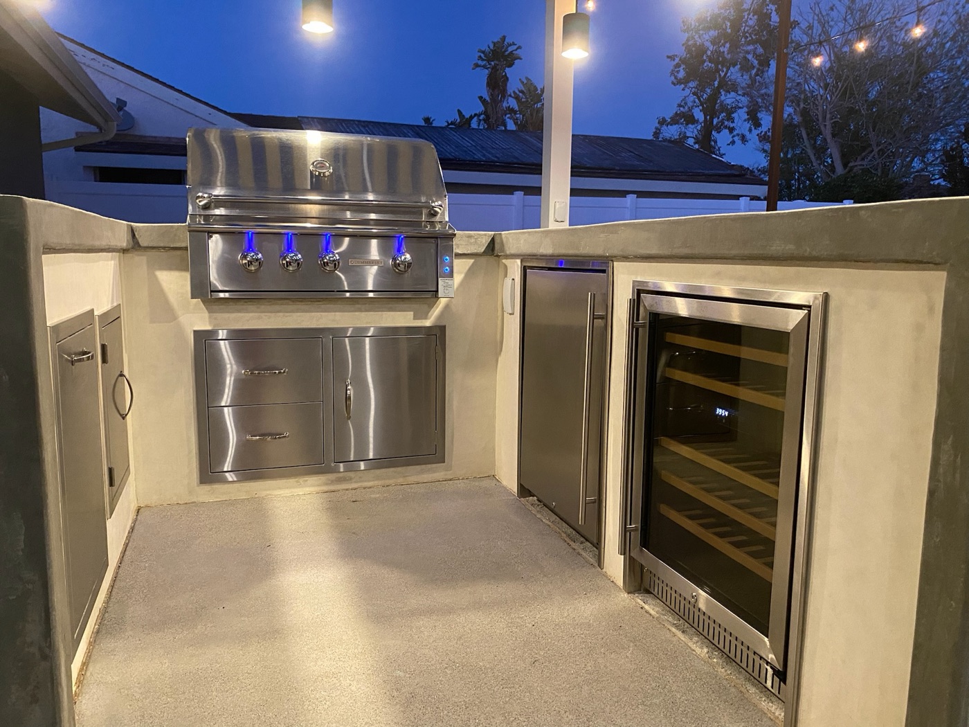 Sleek outdoor kitchen with grill and wine fridge at dusk in Crowley by Abshire Brothers Lawn & Landscape