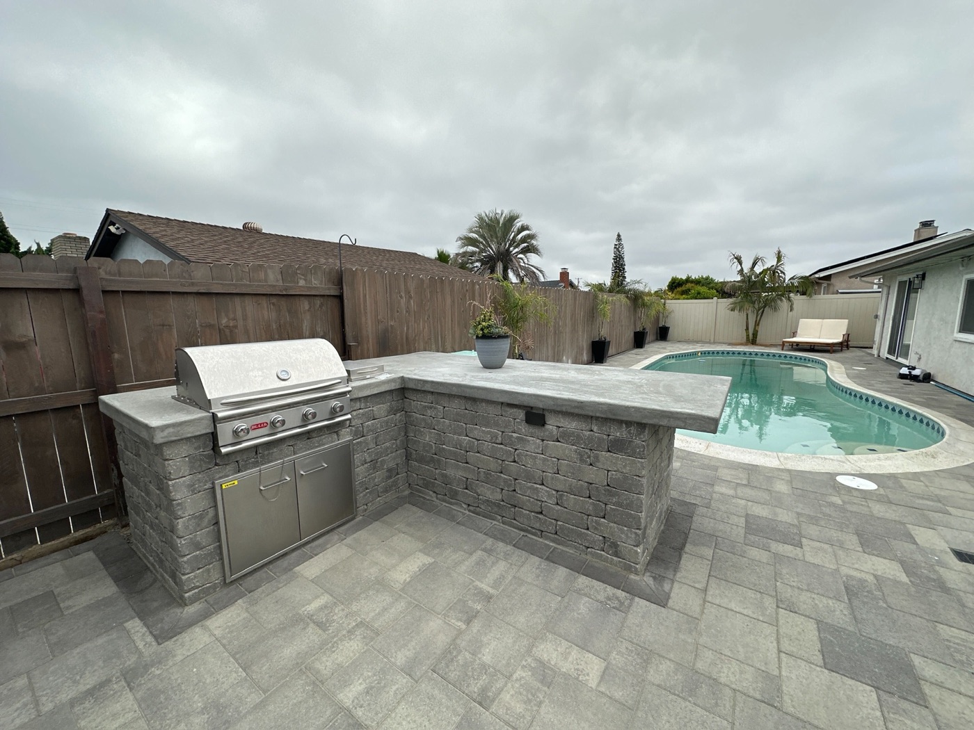 Outdoor kitchen and pool with a paver patio in Crowley by Abshire Brothers Lawn & Landscape