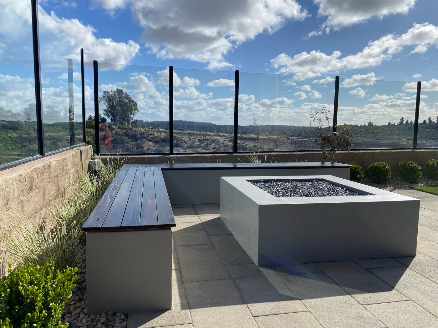 Modern fire table and floating bench overlooking the valley in Crowley by Abshire Brothers Lawn & Landscape