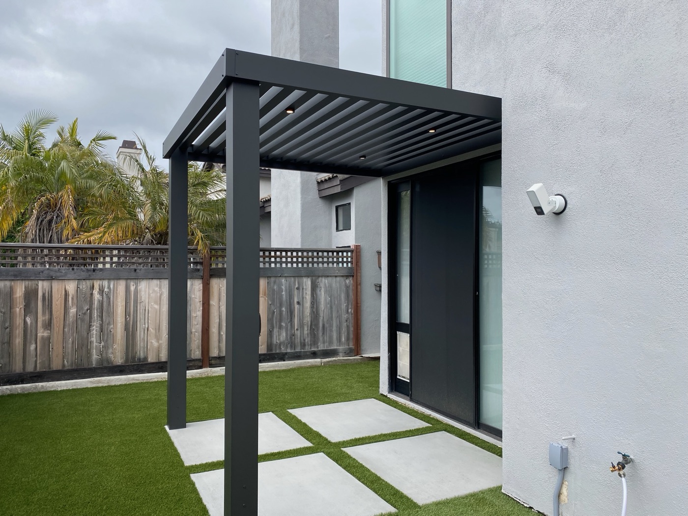 Louvered pergola over turf and pavers in Scott by Abshire Brothers Lawn & Landscape