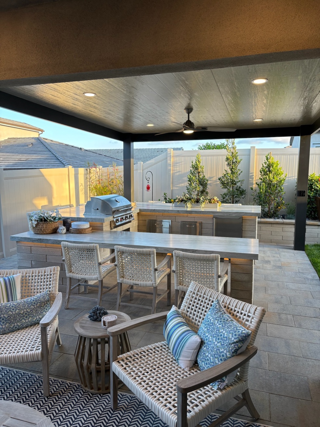 Covered outdoor kitchen and lounge in Broussard by Abshire Brothers Lawn & Landscape