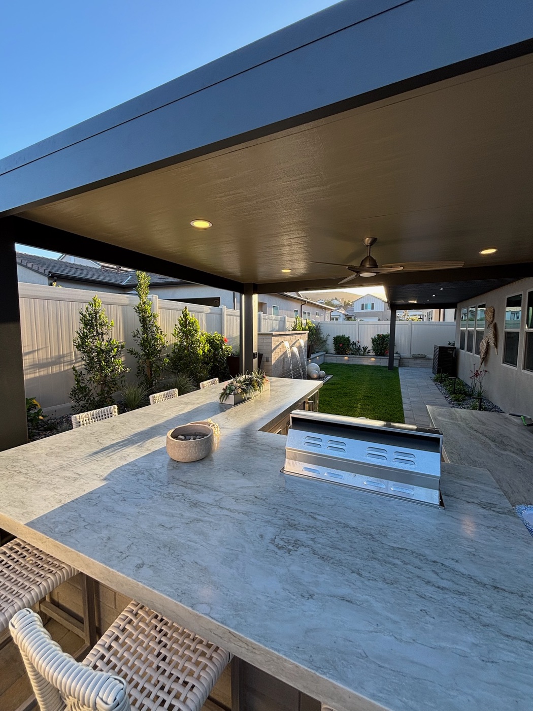 Covered patio with a marble outdoor kitchen in Carencro by Abshire Brothers Lawn & Landscape