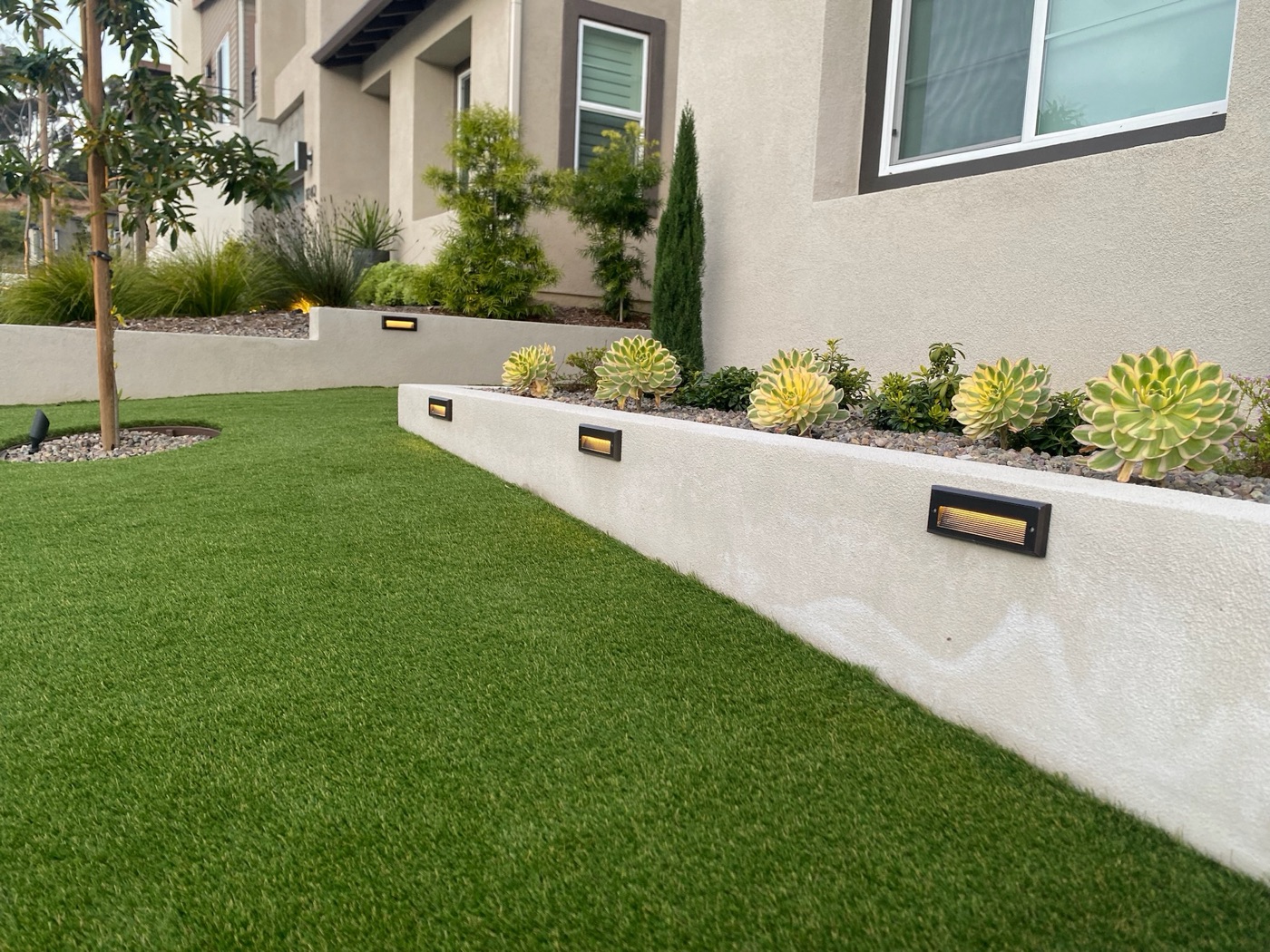 Modern front-yard planter with drought-tolerant planting in Abbeville by Abshire Brothers Lawn & Landscape