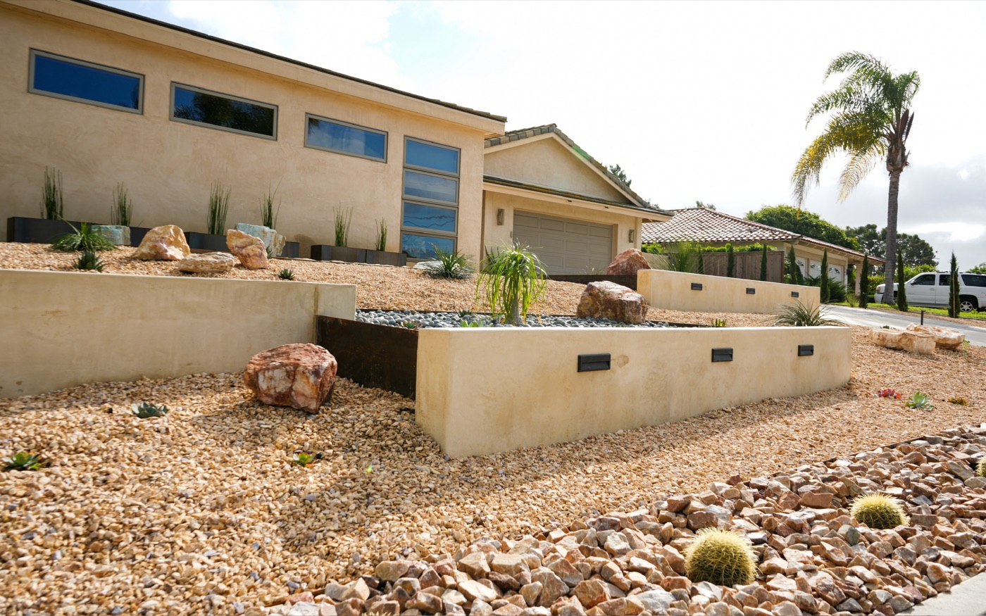 Drought-tolerant front yard with boulders in Eunice by Abshire Brothers Lawn & Landscape