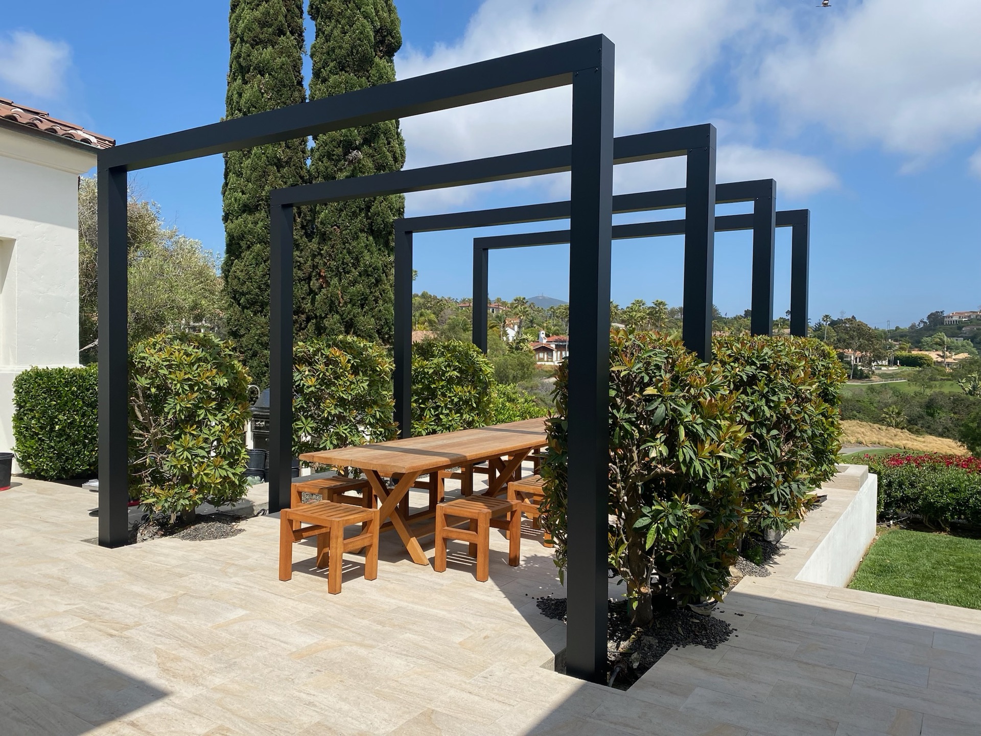 Architectural steel arbor over an estate dining terrace, designed and built by Abshire Brothers Lawn & Landscape in Kaplan, Acadiana