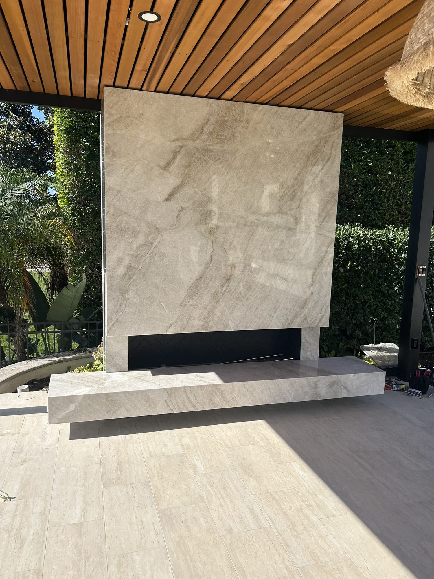 Quartzite fireplace meeting the clear-grain cedar ceiling at the corner