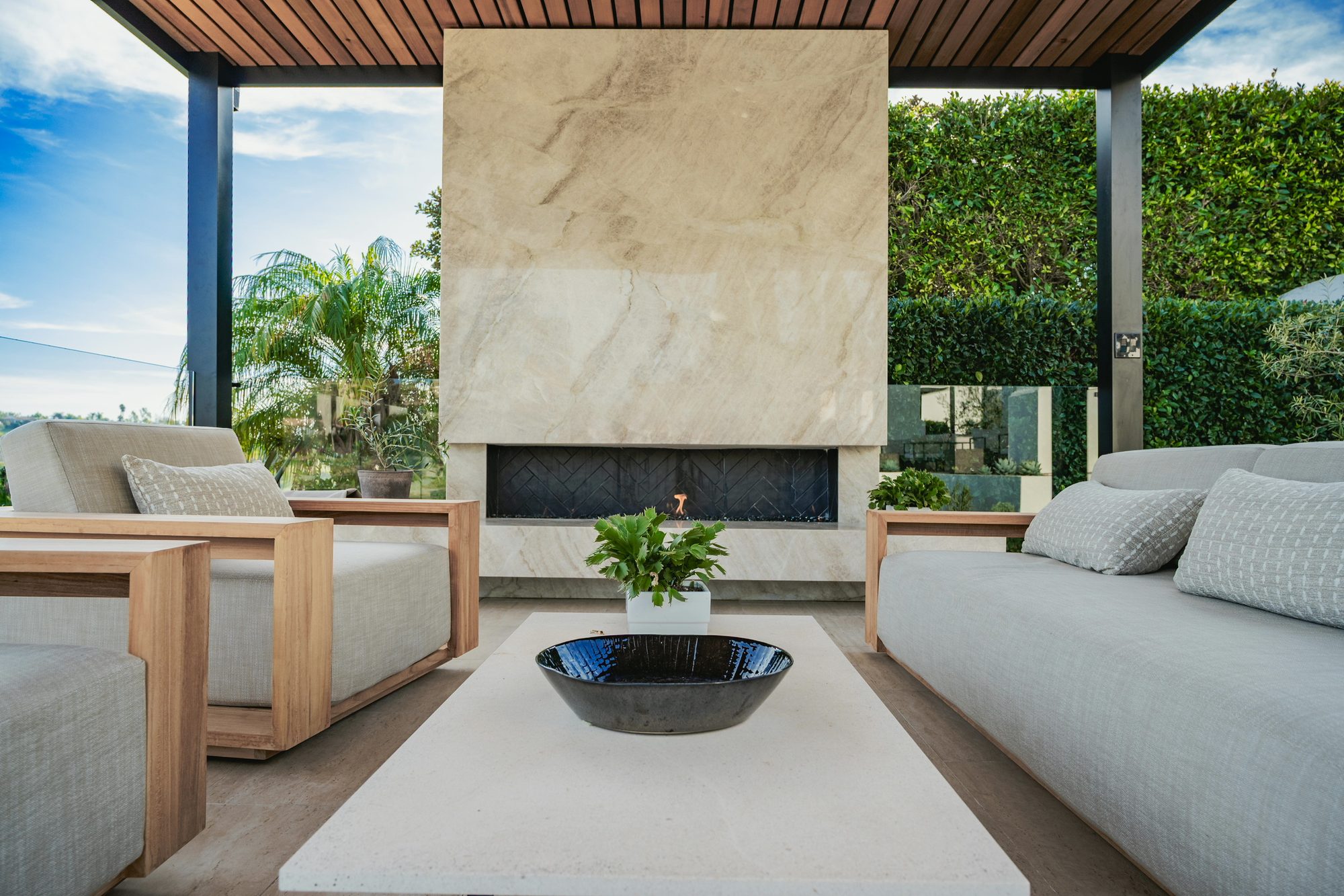 Floor-to-ceiling Taj Mahal quartzite fireplace with a floating hearth beneath a cedar ceiling, Kaplan