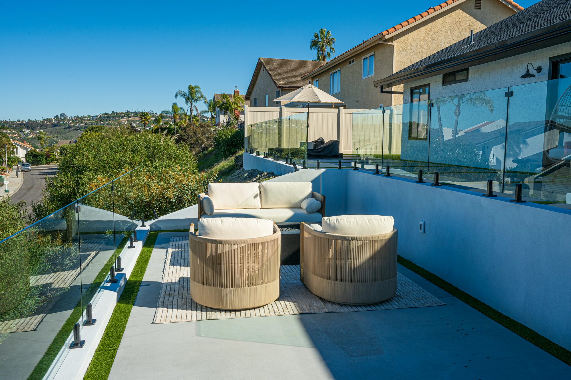 Fire-pit lounge with sofas set against the frameless glass railing and view