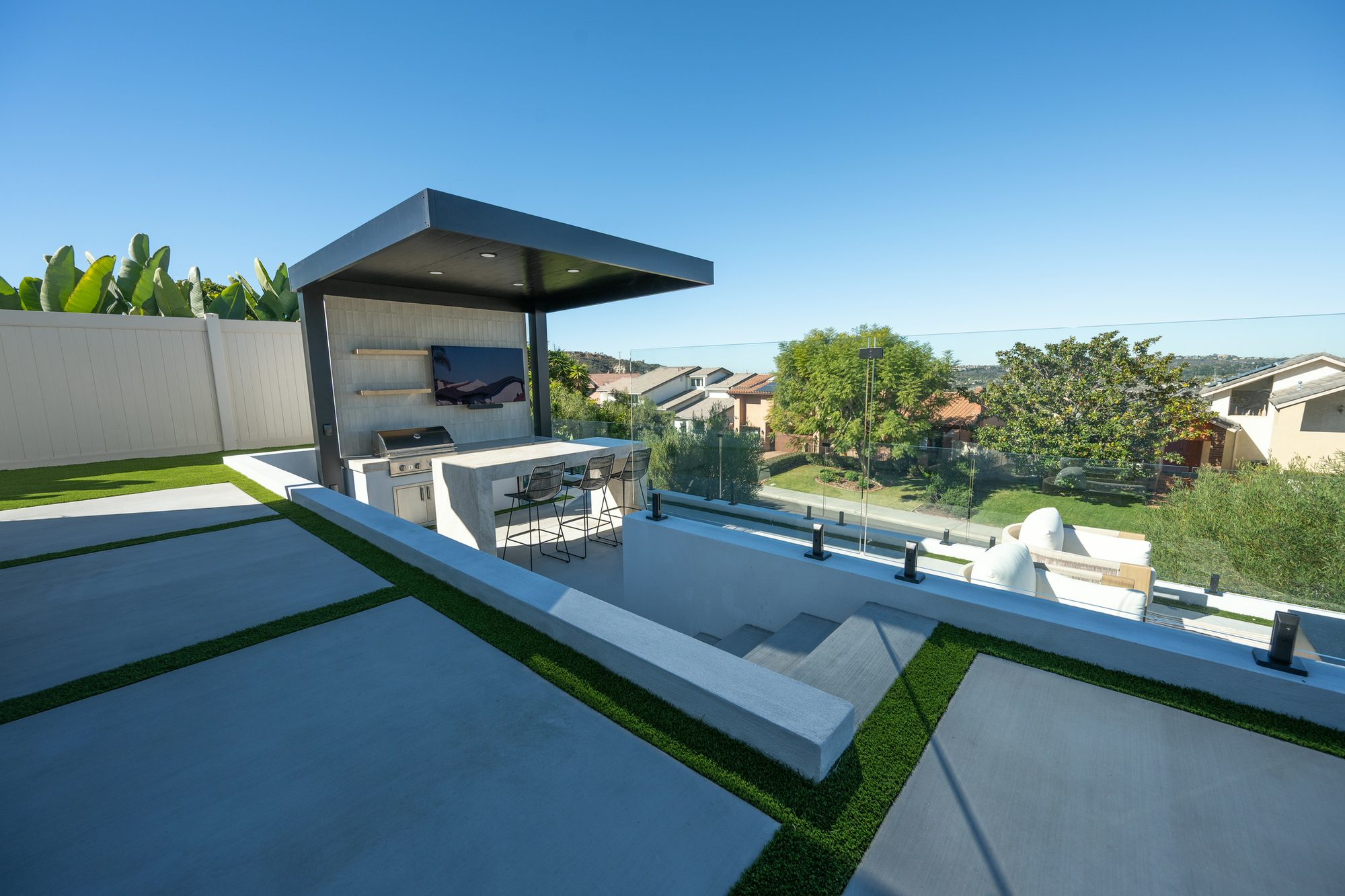 Fire-pit terrace and outdoor kitchen seen across the multiple levels