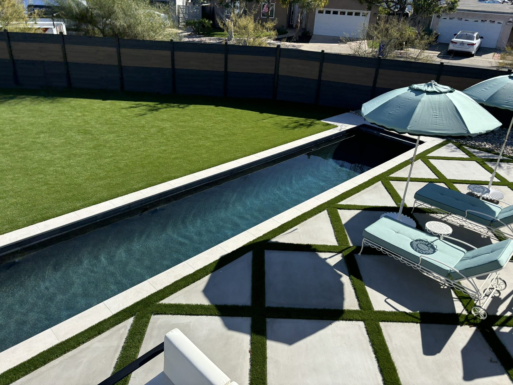 Aerial view of the completed Justin Lang backyard with a lap pool, diamond-patterned concrete and turf inlays in Rayne