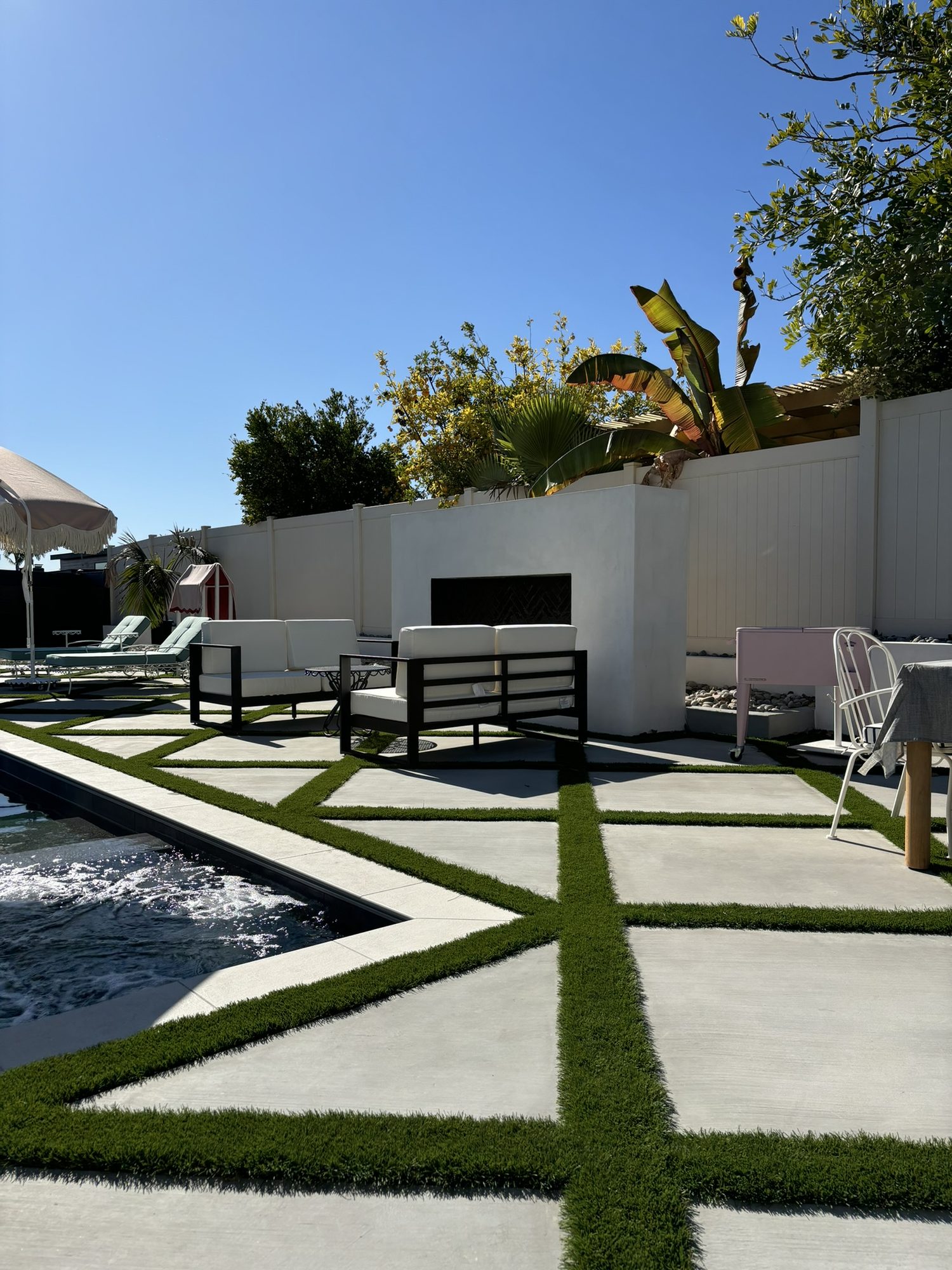 Diamond-patterned pour-in-place concrete with artificial turf inlays beside the pool in the Justin Lang backyard