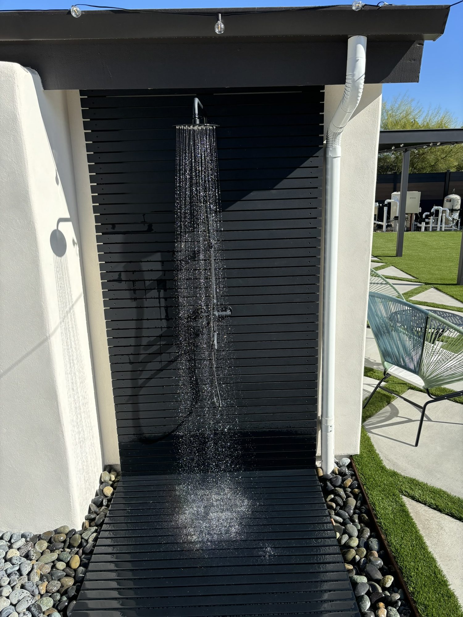 Ipe-wood outdoor shower running beside the pool deck