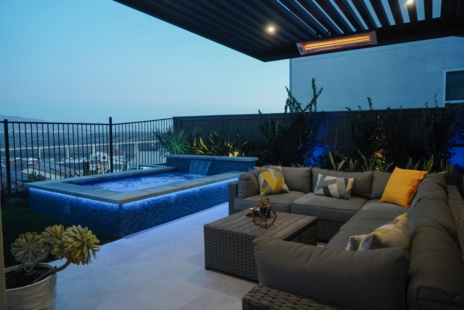 Covered patio at dusk with concealed LED wall lighting and a sectional sofa