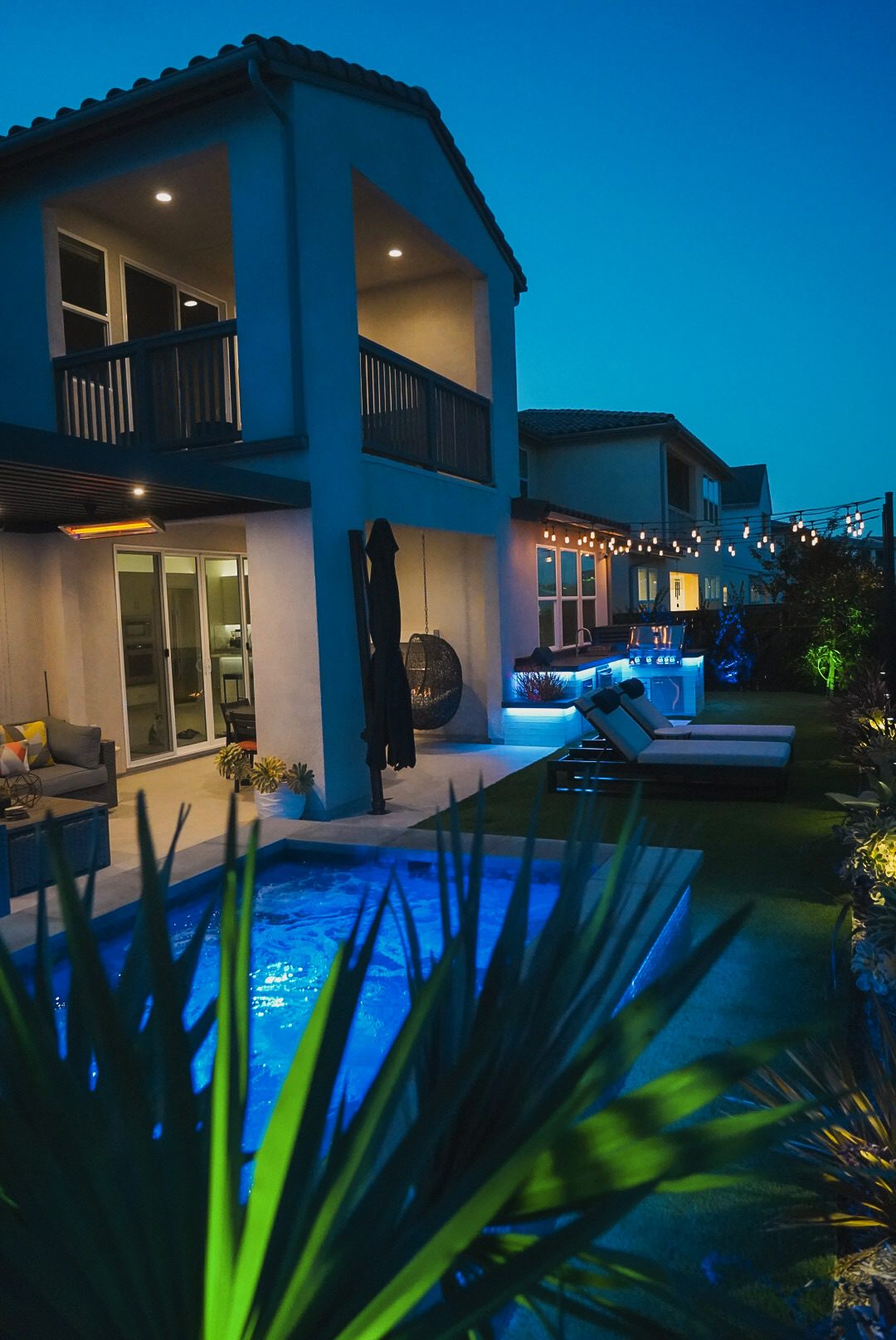 Twilight view of the Kuzma home with the spool glowing blue