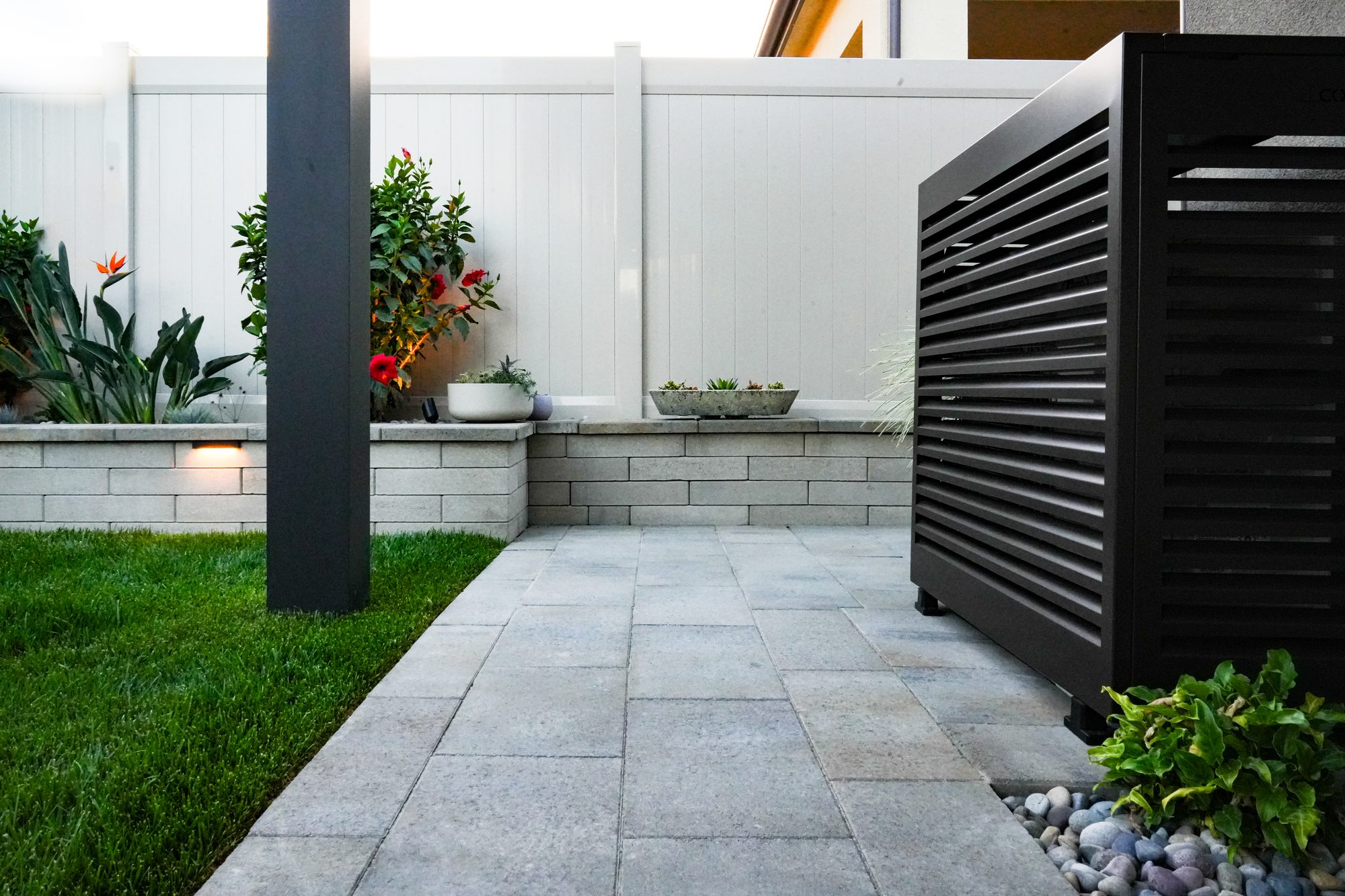 After: a paver patio, Melville-block wall and a louvered screen concealing the AC equipment