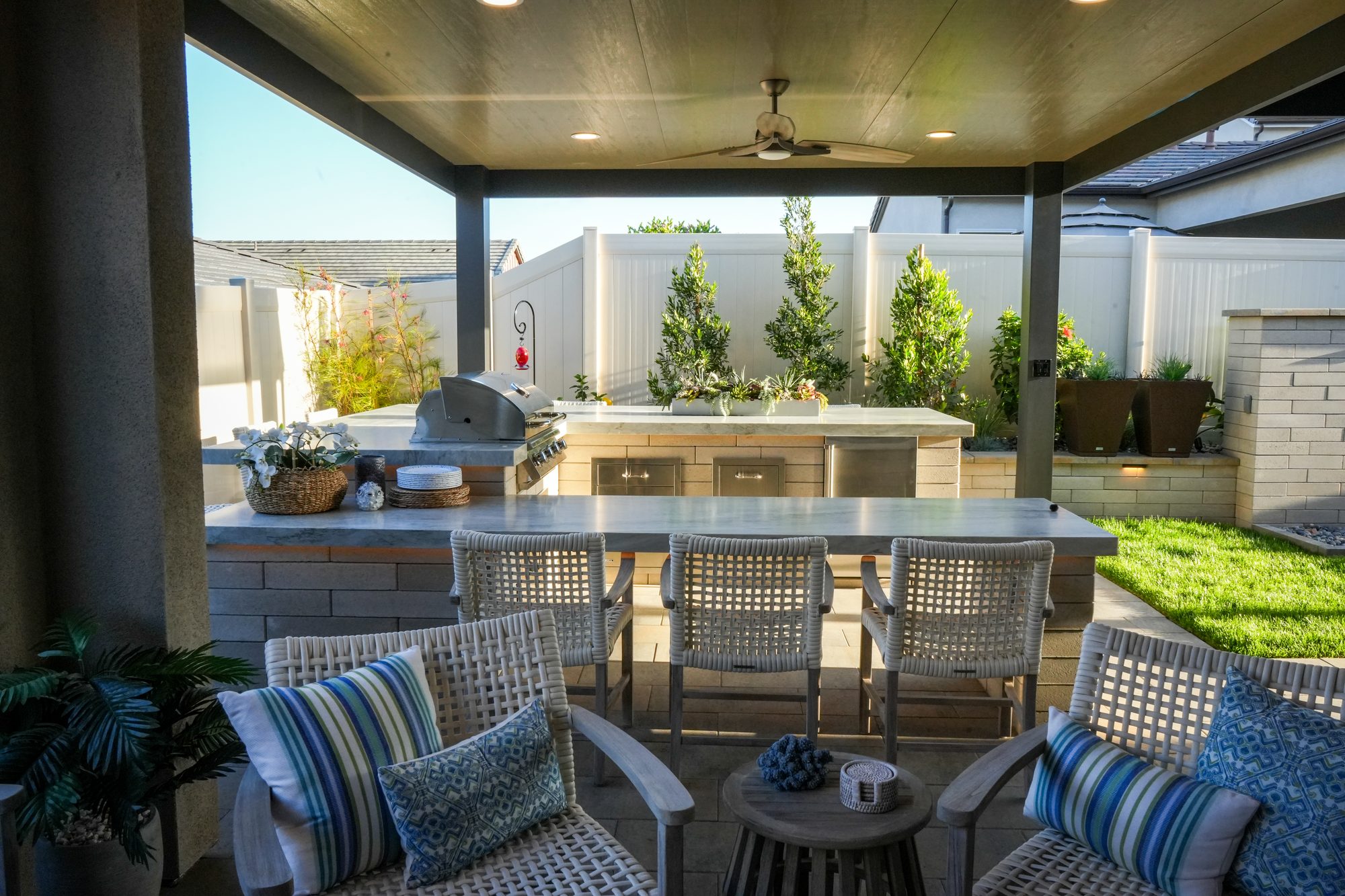 Covered patio with the Melville-block outdoor kitchen, bar seating and sod lawn
