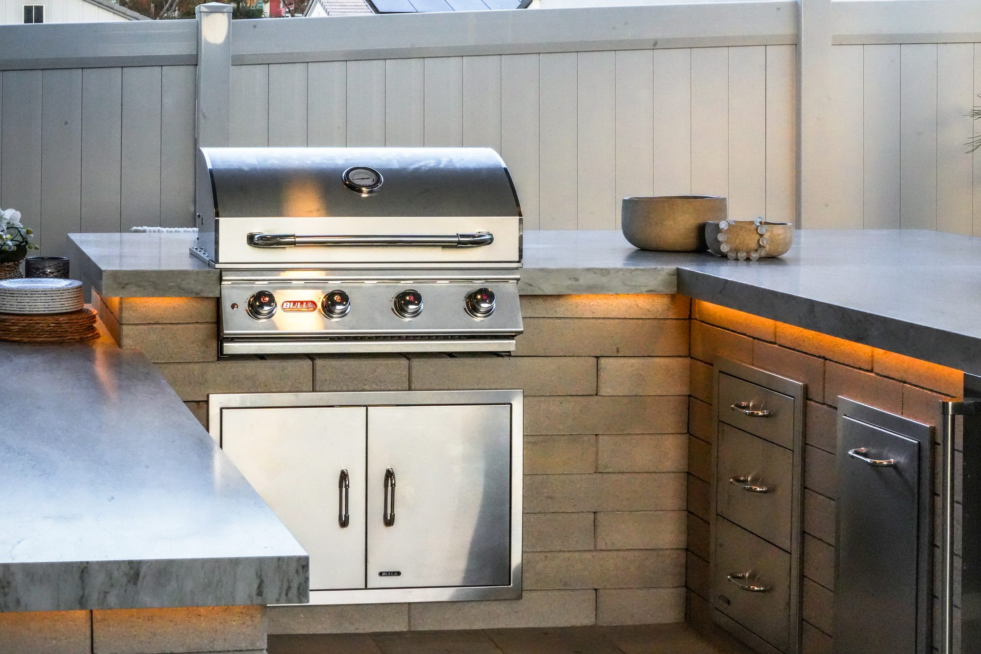 Outdoor kitchen island detail with grill, drawers and mitered counter