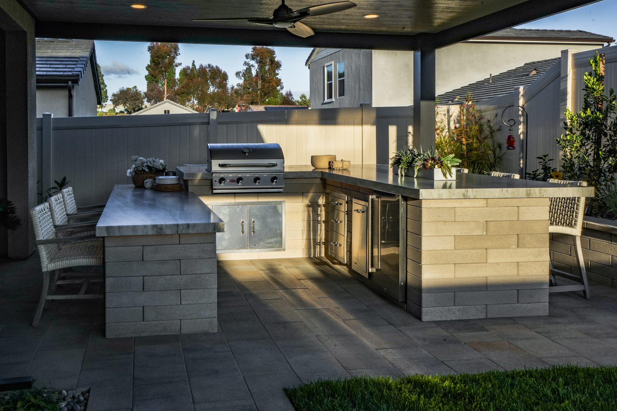 Outdoor kitchen with built-in grill and mitered porcelain counter under the cover
