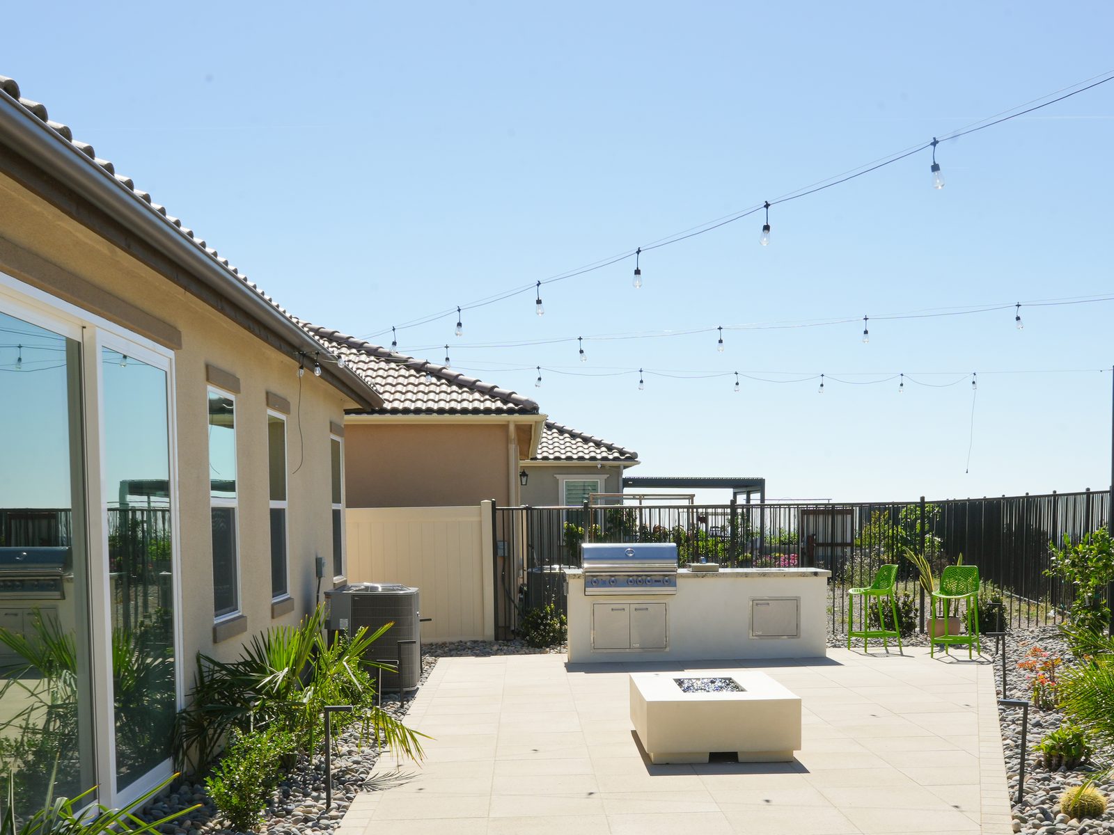 Rectangular gas fire pit table on a paver patio with string lighting, built by Abshire Brothers Lawn & Landscape Rayne